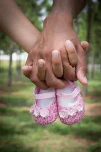 Pregnant couple holding hands, close